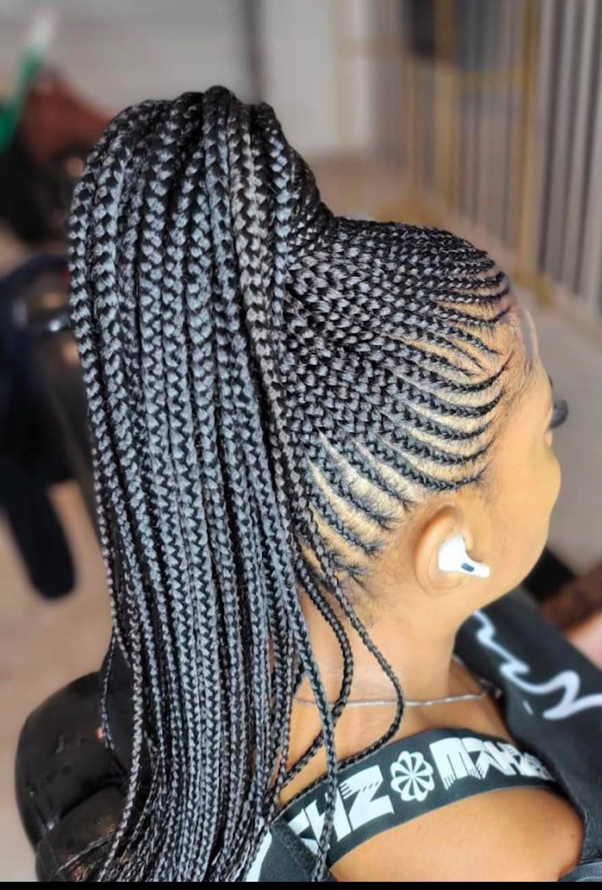 Cornrows gathered into a long braided ponytail